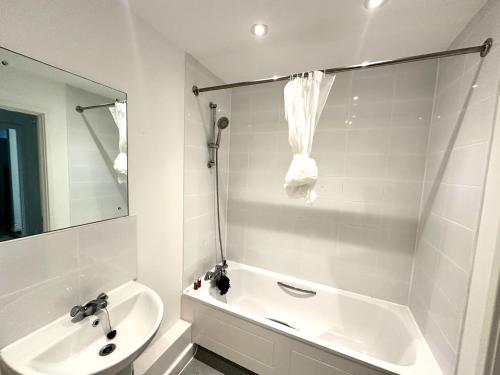 a bathroom with a sink and a tub and a toilet at Beautiful Spacious Kingsize Room Near Oval Station in London