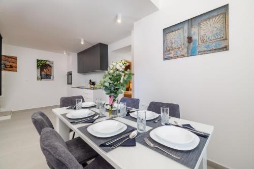 a dining room with a white table and chairs at House Maris in Tribalj
