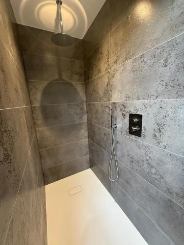 a bathroom with a shower with a shower head at Capsule Avatar - Balneo Sauna Projecteur Nintendo in Mons
