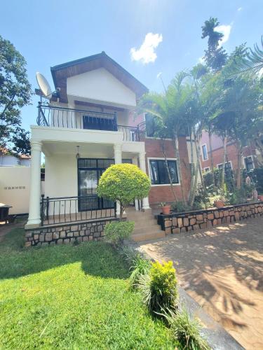 a house with a porch and stairs in front of it at Ecolux rebero residence in Kigali