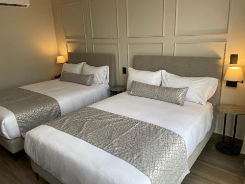 two beds in a hotel room next to each other at OTMÁNN Hotel Boutique in Guadalajara