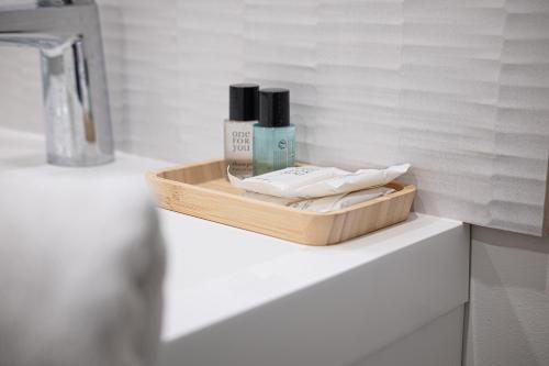 un plateau en bois avec des produits sur un comptoir dans une salle de bain dans l'établissement Elegant Apartment City center Cathedral, à Reims