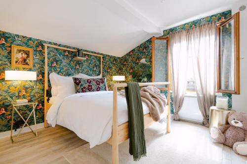 - une chambre avec un grand lit et du papier peint floral dans l'établissement Abandonner son quotidien.. C.L.S Deauville, à Deauville