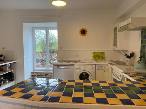 a kitchen with a checkered floor in a kitchen at La Pagerie in Maupertuis