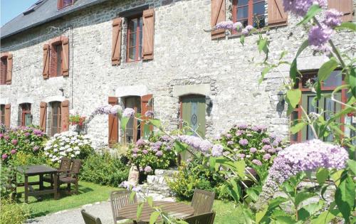 a stone building with a bunch of flowers in front of it at La Pagerie in Maupertuis