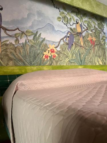 a painting on the wall above a bed in a room at Hotel Quinta Bella in Tula de Allende