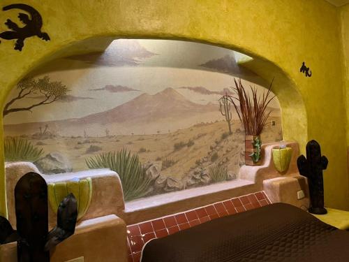 a bedroom with a painting on the wall at Hotel Quinta Bella in Tula de Allende