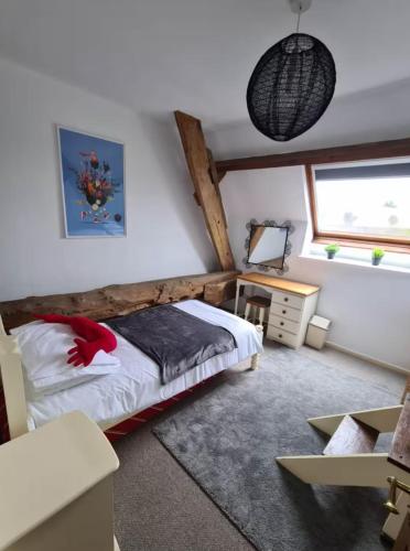 a bedroom with a bed and a desk and a window at La Pagerie in Maupertuis