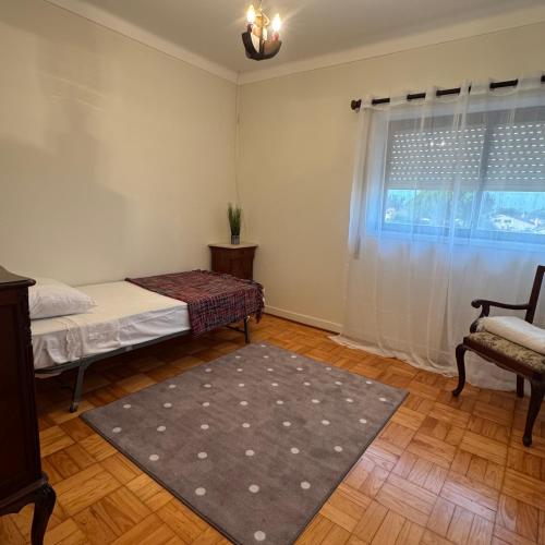 a room with a bed and a chair and a window at Casa de férias in Monte