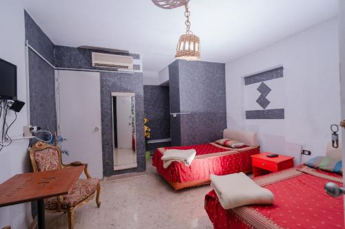 a bedroom with two beds and a table and a mirror at ksar el afia in Jendouba