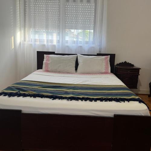 a bedroom with a large bed with a window at Casa de férias in Monte
