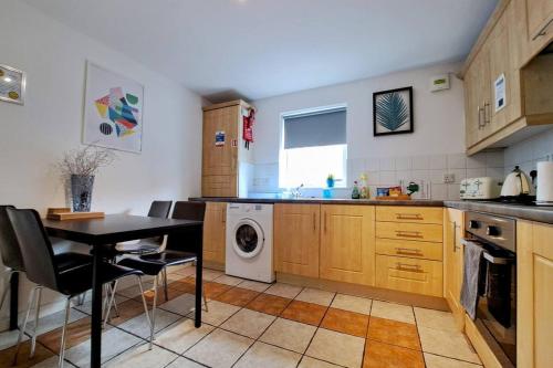 a kitchen with a table and a washing machine at Kings Lodge Apartment & Patio in Belfast