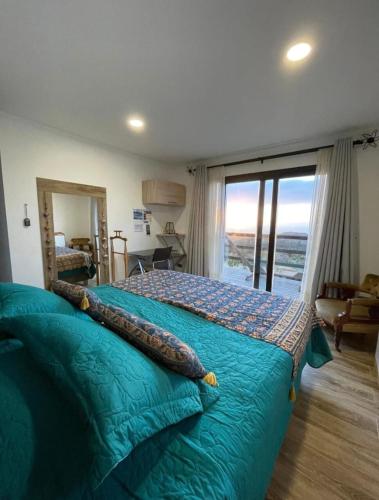 ein Schlafzimmer mit einem Bett und einem großen Fenster in der Unterkunft Exclusiva casa con hermosa vista in Los Molles