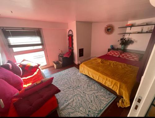 une chambre avec un lit et un canapé dans l'établissement Charmant Duplex aux Portes de Paris, à Ivry-sur-Seine