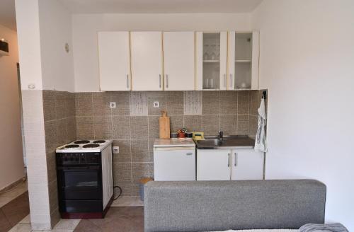 a kitchen with white cabinets and a sink and a stove at Perfect Location close to Jaz beach - Apartments Rora Knezevic in Budva