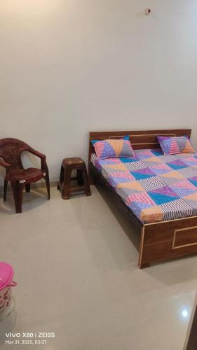 a bedroom with a bed and a chair at Ayush guest house in Mirzāpur