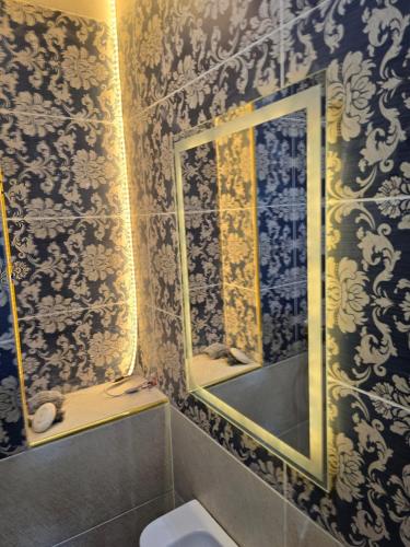 a bathroom with a mirror and a sink and a toilet at Pyramids Private Gate in ‘Ezbet `Abd el-Ḥamîd