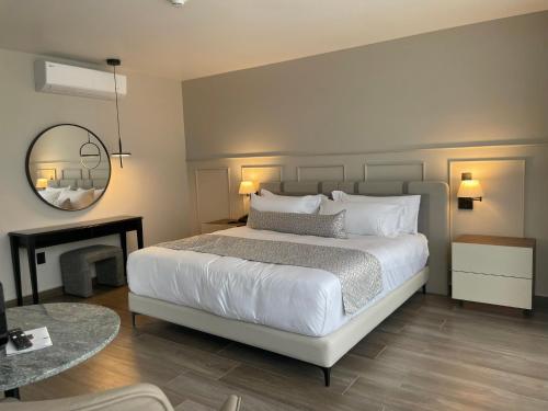 a bedroom with a large white bed and a fireplace at OTMÁNN Hotel Boutique in Guadalajara