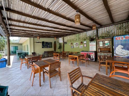 a restaurant with wooden tables and wooden chairs at Hotel Vicino al Mare - Frente mar in Guarujá