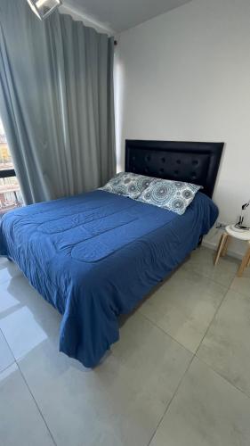 a bedroom with a bed with a blue comforter at Torres Brickell Plaza. in Tigre