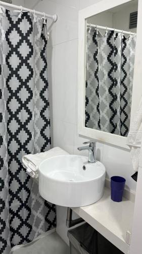 a bathroom with a sink and a shower curtain at Torres Brickell Plaza. in Tigre