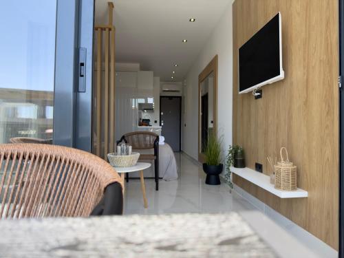 a living room with a television on a wall at Mare Luxury Studios in Kallithea Halkidikis