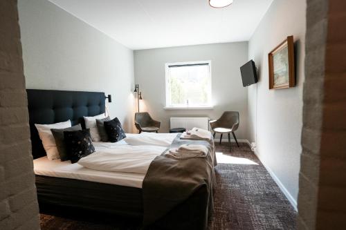 En eller flere senge i et værelse på Hotel Postgaarden