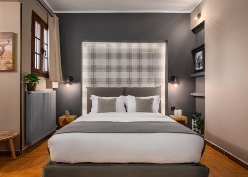 a bedroom with a large bed and a large window at Leonidas by GM Luxury Suites Kalavryta in Kalavrita