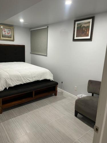 a bedroom with a bed and a chair and a chalkboard at Cozy and comfy 1 BEDROOM basement suite at Cougar ridge SW Calgary in Calgary