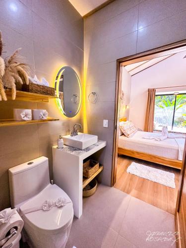 a bathroom with a toilet and a sink and a bed at Yiven Natural Village in Puerto Viejo