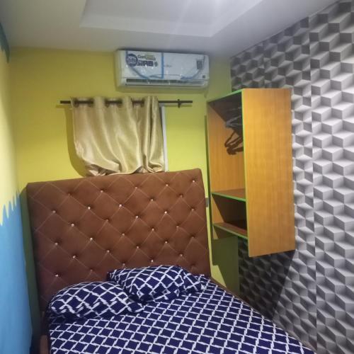 a bedroom with a bed with a brown head board at Effizy Royal Empire and Party Garden in Ibadan