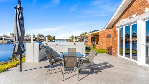 a patio with a table and chairs and an umbrella at Friendship Key in Forster