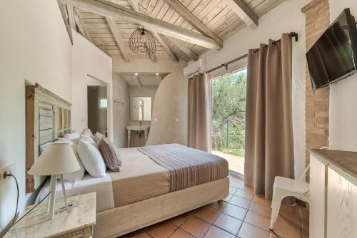 a bedroom with a bed and a large window at JARDIN de VILLE in Lithakia