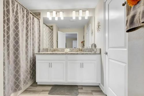 a white bathroom with a sink and a mirror at Waterpark Disney wPoolLakeView Storey Lake in Kissimmee