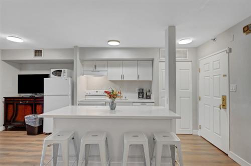 a kitchen with a large white counter and stools at Stay Together Suites - Condominium Sleeps 9 With Strip View - NO RESORT FEES in Las Vegas