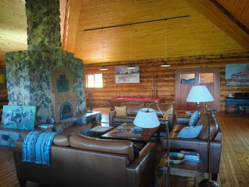 a living room with leather couches and a fireplace at Smithers Driftwood Lodge in Smithers