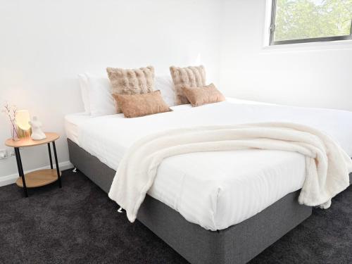 Un dormitorio con una cama con sábanas y almohadas blancas. en Glen’s Fitz St Getaway - Central, en Wagga Wagga