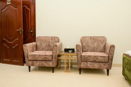 two chairs and a table in a room at Ocean Pearl Hotel in Karachi
