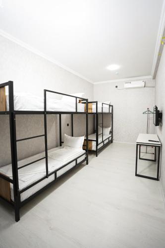 a room with three bunk beds and a table at City hostel in Termiz