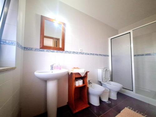 a bathroom with a sink and a toilet and a mirror at Quinta das Carvalhas in Neiva