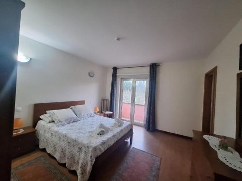 a bedroom with a bed and a large window at Quinta das Carvalhas in Neiva