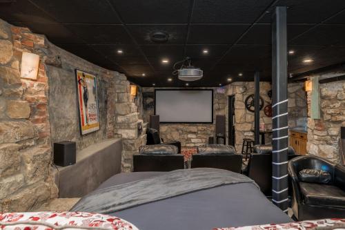 a stone walled room with a bed and a screen at Laven House in Mankato