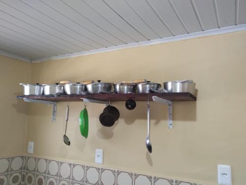 un estante con ollas y sartenes en la pared en Hostel Da Ladeira, en Ouro Preto