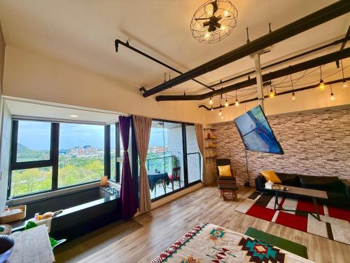 a living room with a couch and a large window at 宜蘭頭城A Happy Birthday 私人溫泉 海景 蘭陽夜景大陽台無邊際泳池 in Toucheng