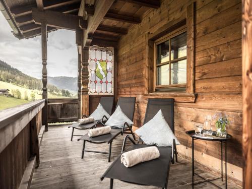 a porch of a wooden cabin with chairs and a window at Birkheim in Inneralpbach