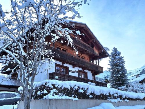 a building covered in snow next to a tree at Birkheim in Inneralpbach