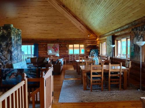 a dining room with tables and chairs in a cabin at Smithers Driftwood Lodge in Smithers
