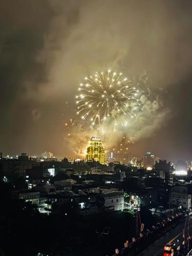 a firework display over a city at night at 宜蘭頭城A Happy Birthday 私人溫泉 海景 蘭陽夜景大陽台無邊際泳池 in Toucheng
