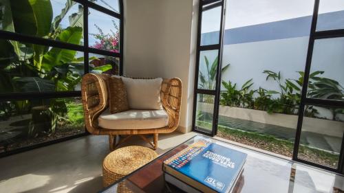 a room with a chair and a table with a book at The White House in Tuy Hoa