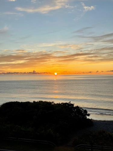 a sunset over the water with the sun in the sky at Taitung Blue Sea Villa in Chenggong